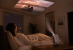 BenQ GV50 posé sur une table de nuit et orienté vers le plafond pour regarder un film depuis un lit