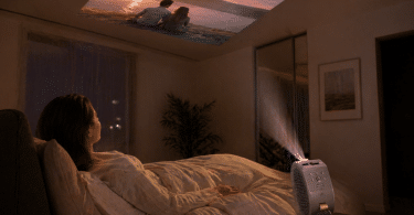 BenQ GV50 posé sur une table de nuit et orienté vers le plafond pour regarder un film depuis un lit