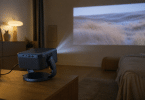 Vidéoprojecteur Epson EF-22N posé sur un meuble bas, branché au secteur et projetant une image sur un mur dans une pièce assombrie
