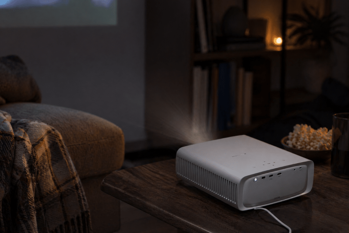 Mini vidéoprojecteur PHILIPS NeoPix 550 posé sur une table basse dans un salon sombre pour une soirée film