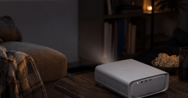 Mini vidéoprojecteur PHILIPS NeoPix 550 posé sur une table basse dans un salon sombre pour une soirée film