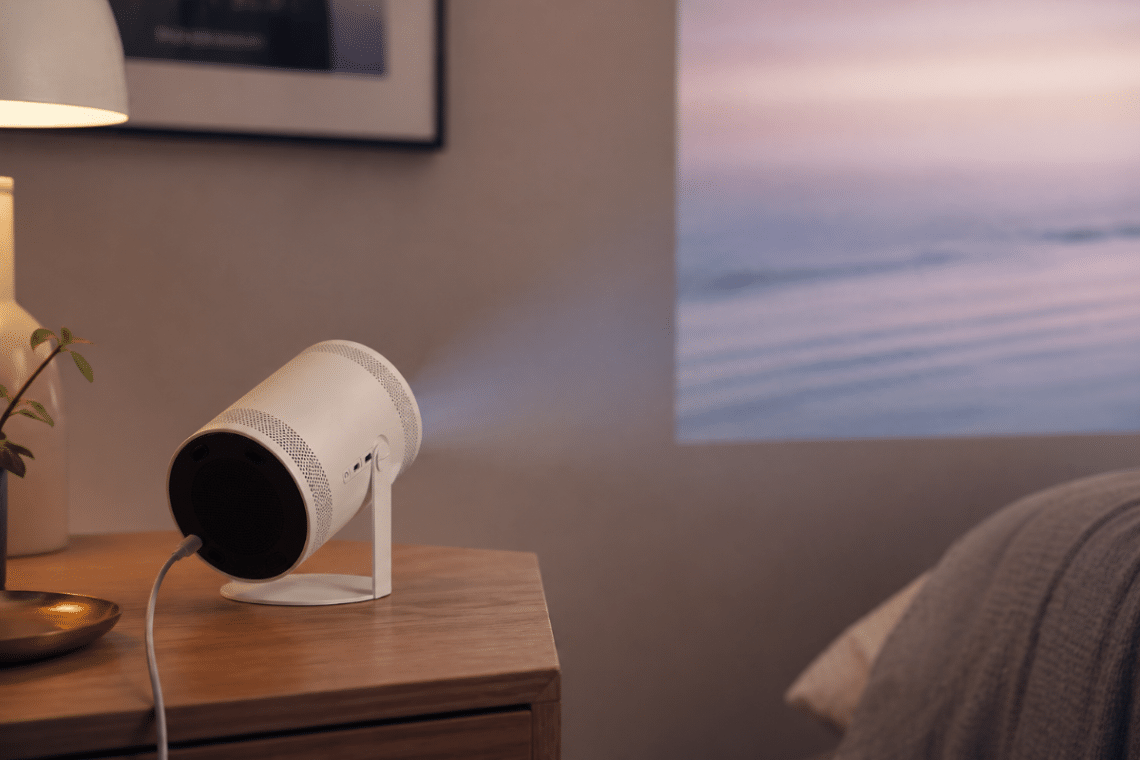 Samsung The Freestyle 2nd Gen posé sur un meuble et projetant une image sur un mur dans une pièce moderne