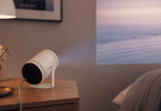 Samsung The Freestyle 2nd Gen posé sur un meuble et projetant une image sur un mur dans une pièce moderne