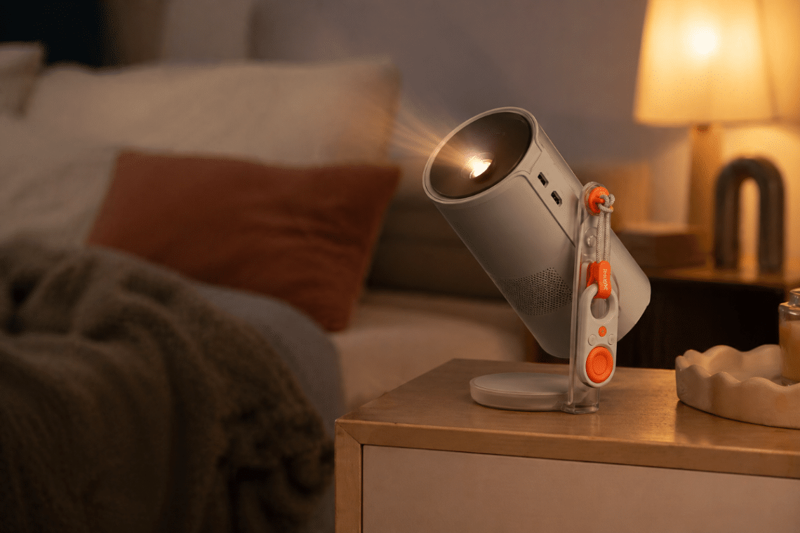 XGIMI MoGo 4 posé sur un meuble dans une chambre assombrie, orienté vers un mur pour projeter un film