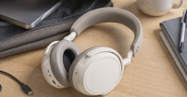 Sennheiser Momentum 4 Wireless posé sur une table avec câble USB-C et sac ouvert, dans un environnement de travail ou de déplacement