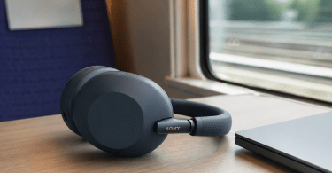 Sony WH-1000XM6 posé sur une tablette de train près d’un ordinateur portable, dans une scène de voyage réaliste